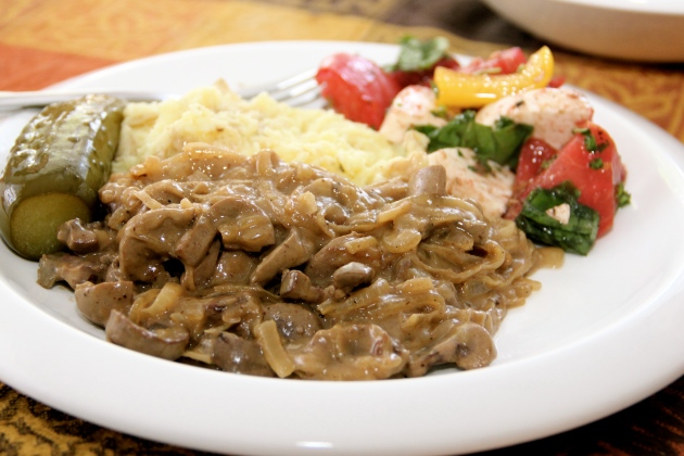 Veal Kidney Stroganoff served with mashed potatoes, pickle, and basic tomato salad